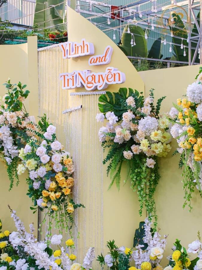 Decor vách chụp hình tone vàng rèm pha lê, hoa lụa nghệ thuật.