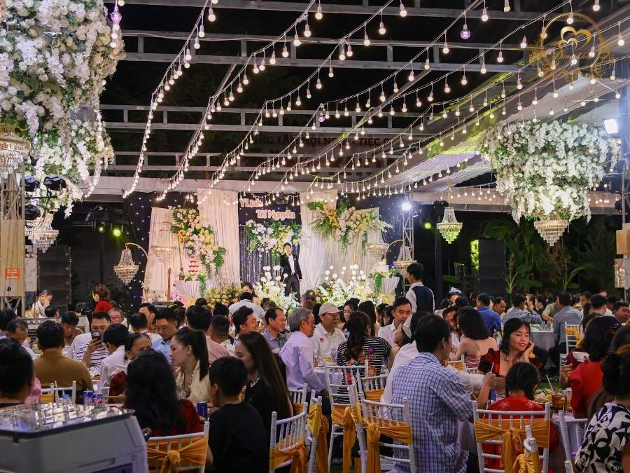 Toàn cảnh tiệc cưới ngoài trời trong đêm: hệ thống đèn dây & trần hoa lộng lẫy
