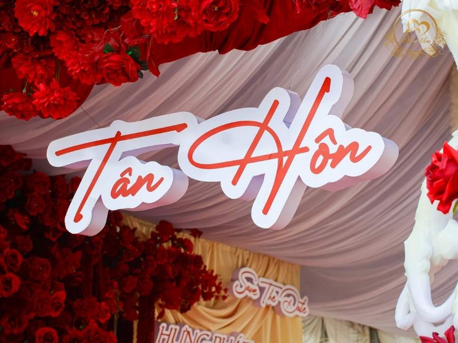 Bảng chữ Tân Hôn tone đỏ trên cổng hoa Rồng Phụng được trang trí hoa lụa cao cấp.