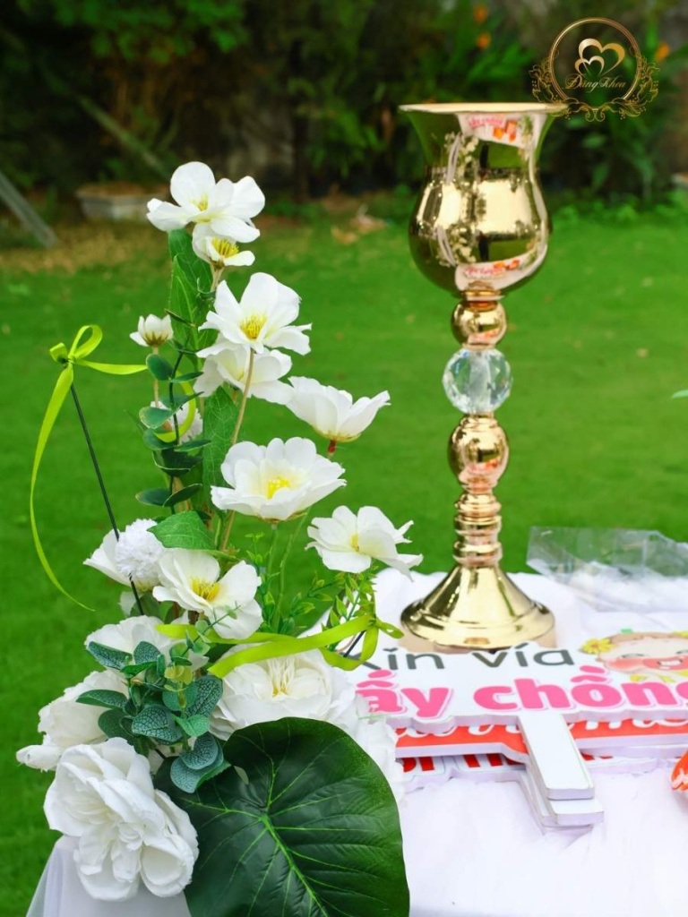 Phụ kiện bình hoa vàng đồng và props chụp hình trên bàn gallery.