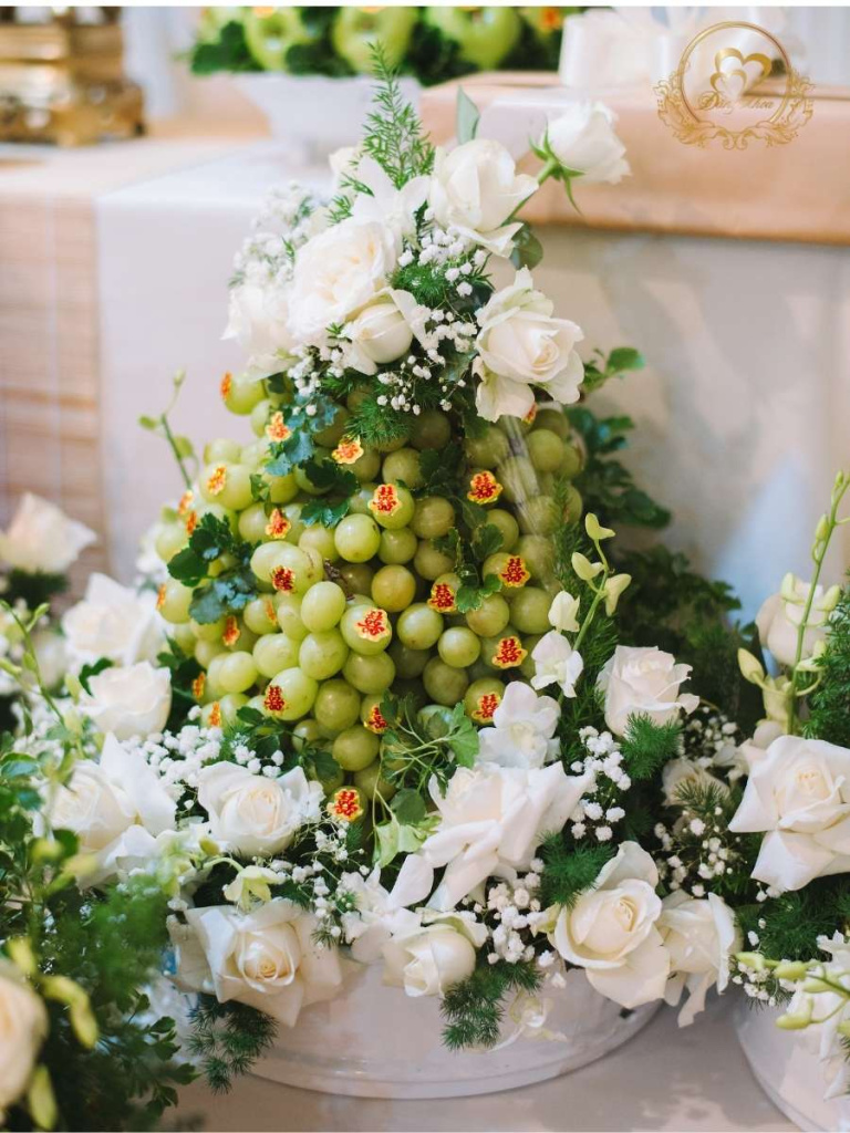 Mâm nho xanh trang trí hoa tươi tone trắng.