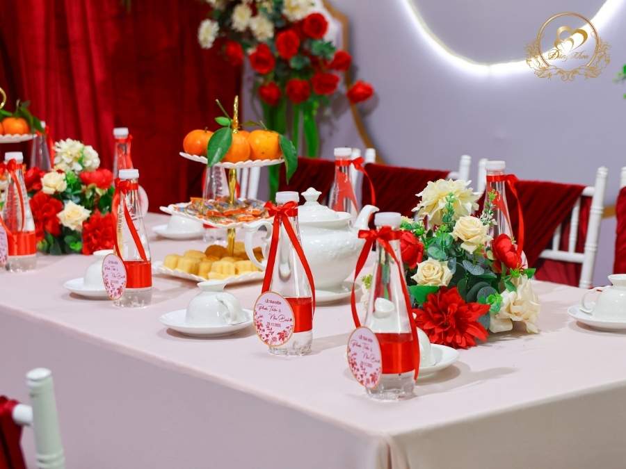 Setup bàn hai họ chu đáo: Tráp trái cây, ấm chén sứ trắng, ghế Tiffany thắt nơ đỏ.
