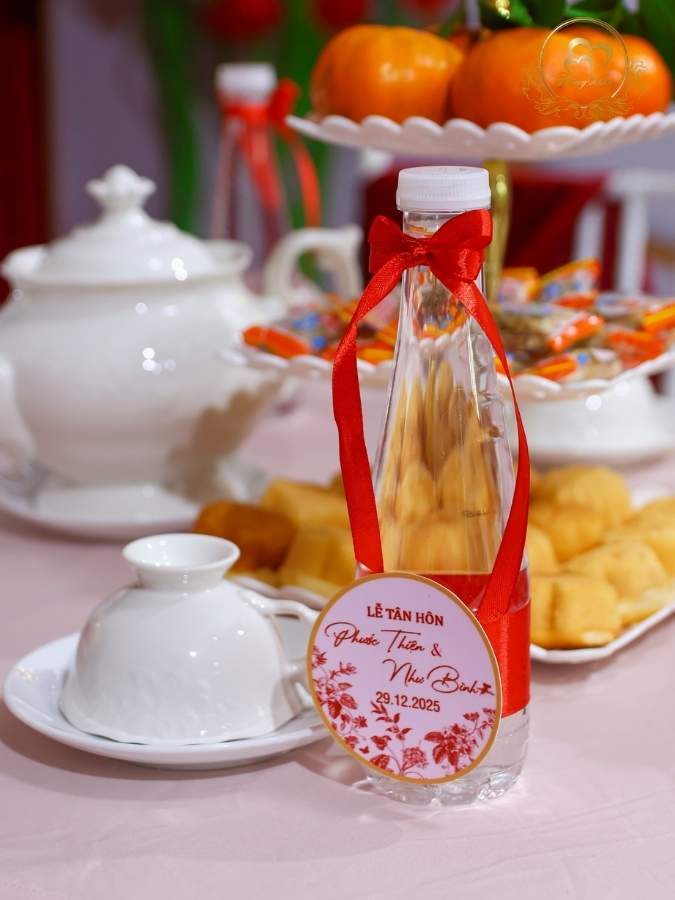 Chai nước suối in tên riêng thắt nơ đỏ dành cho khách mời.