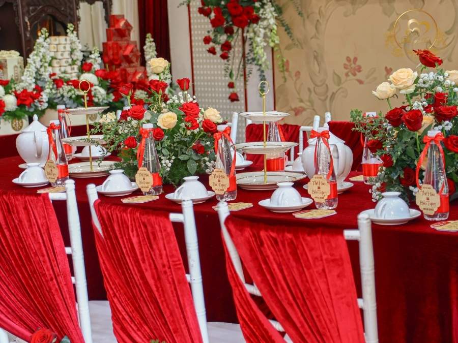 Setup bàn hai họ Lễ Tân Hôn: khăn trải nhung đỏ và ghế Tiffany cao cấp.