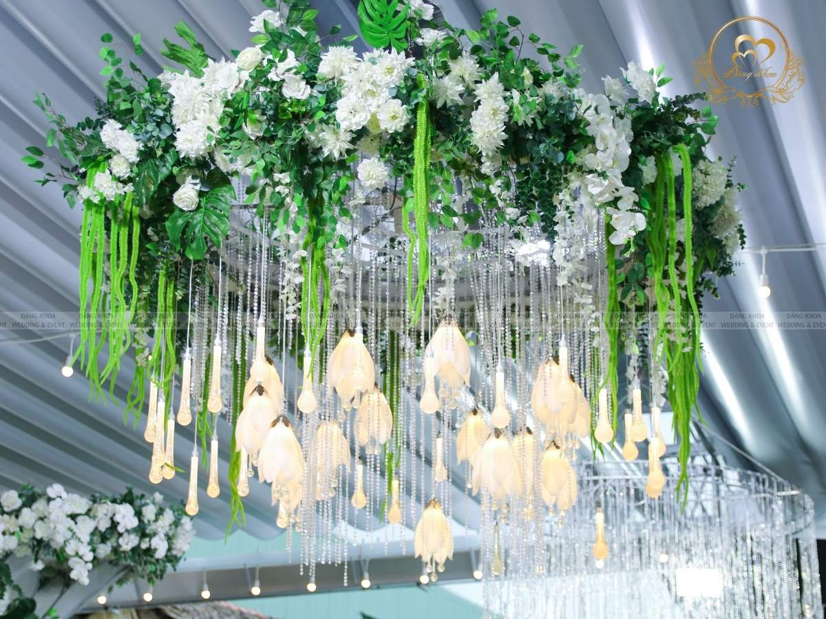 Trang trí trần rạp cưới đẳng cấp với vòng hoa treo và đèn thả pha lê.