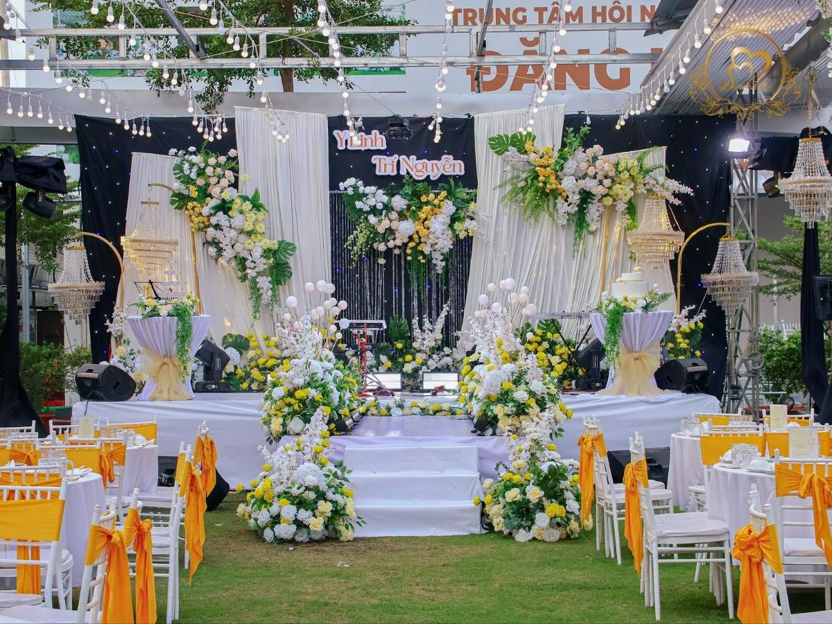 Sân khấu cưới ngoài trời tone trắng vàng.