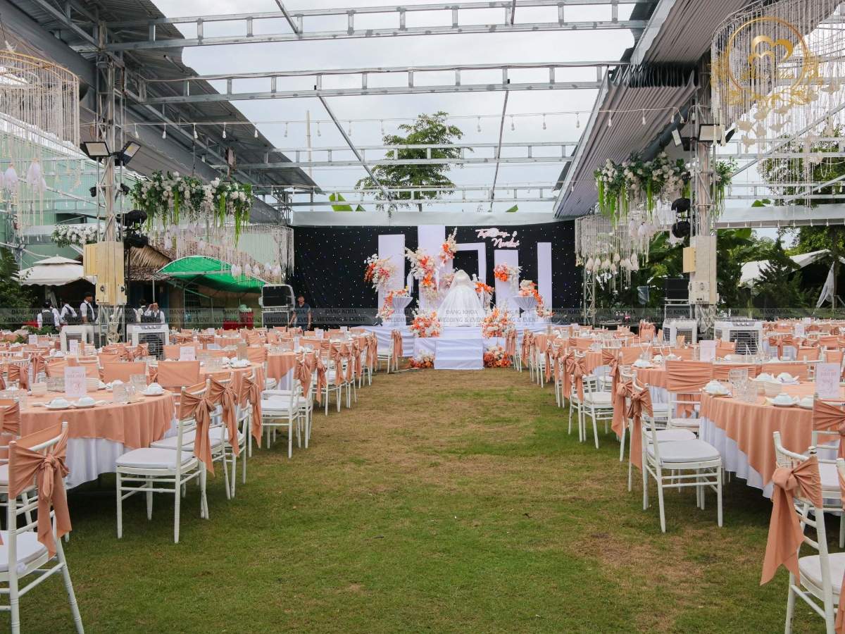 Setup bàn tiệc cưới chỉn chu và ghế Tiffany thắt nơ màu cam đào đồng bộ.