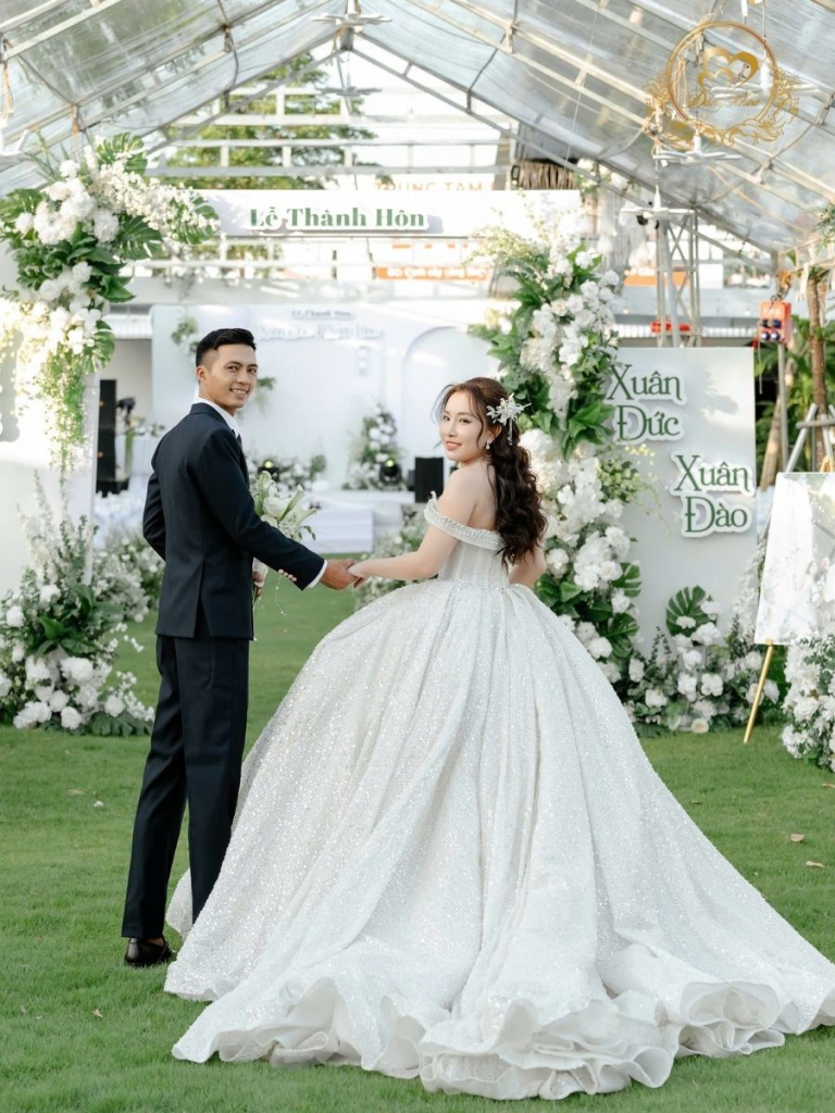 Cô dâu chú rể trong không gian tiệc cưới ngoài trời lãng mạn.