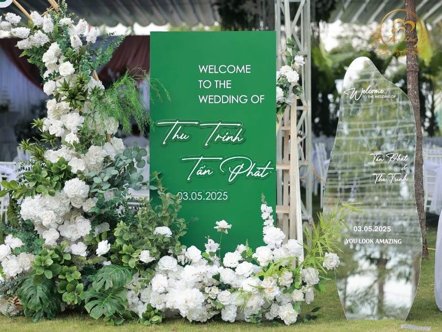 Khu vực bảng welcome và gương check-in đám cưới tone xanh Emerald hiện đại.