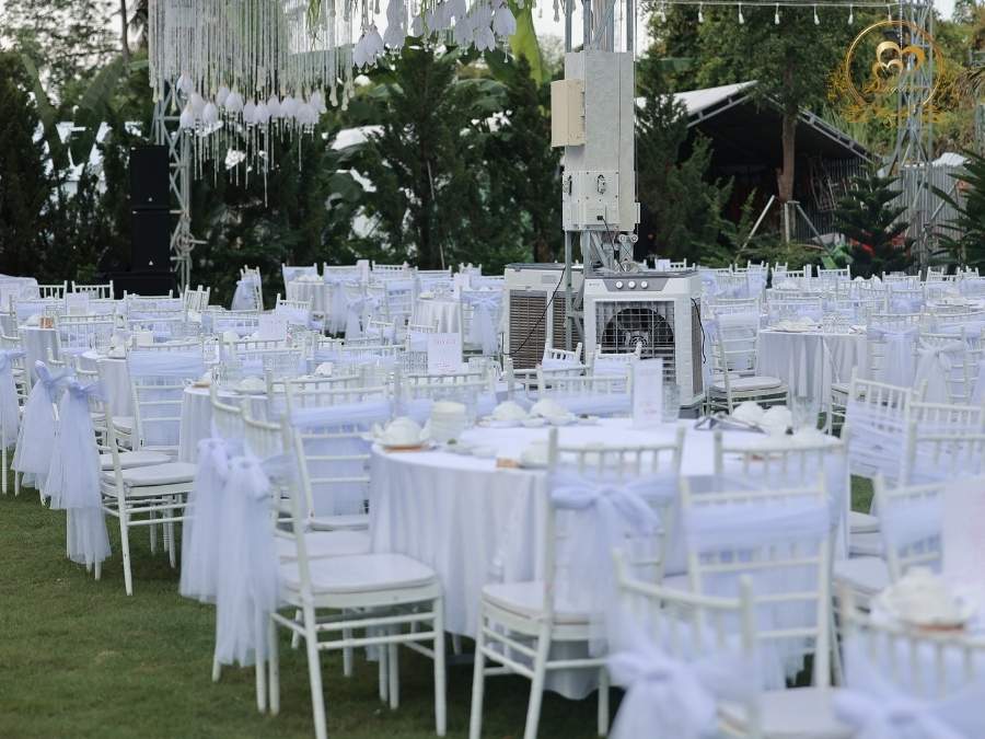 Setup bàn tiệc cưới ngoài trời ghế Tiffany trắng và khăn trải bàn.